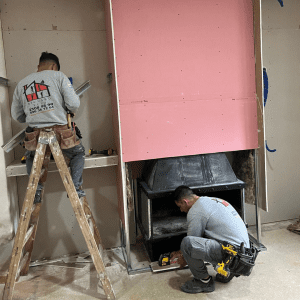 Dos instaladores colocando placa de yeso ignífuga en obra en Montevideo