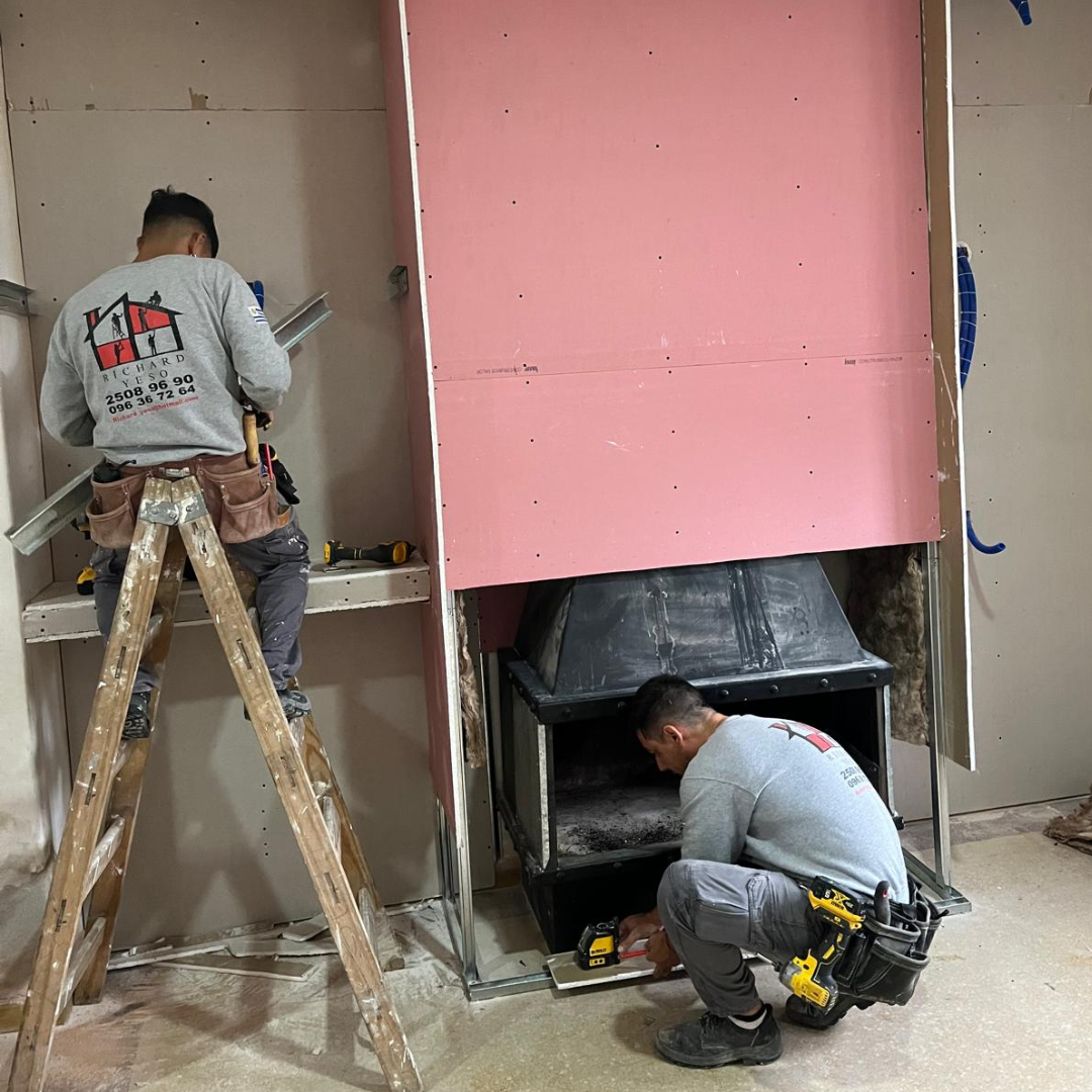 Dos instaladores colocando placa de yeso ignífuga en obra en Montevideo